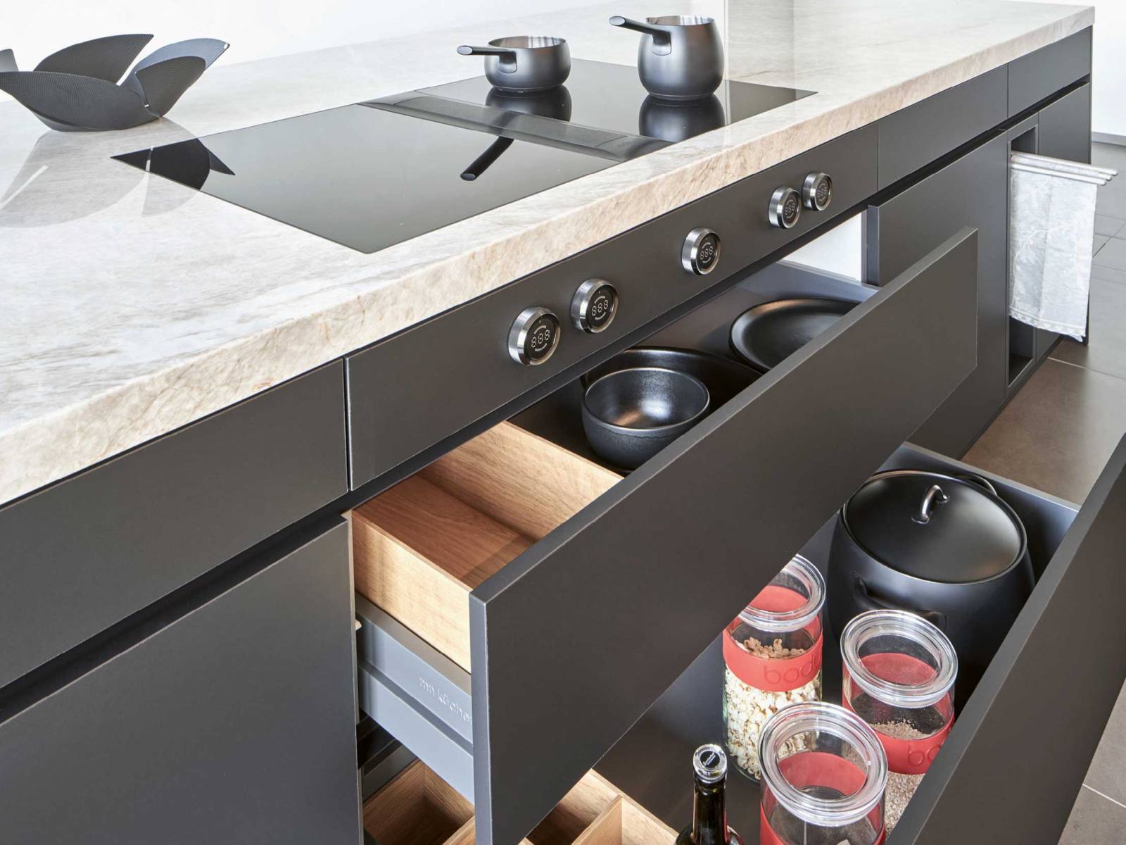 Die Küche «Ligna Elegance» des Liechtensteiner Küchenbauers wirkt modern und grosszügig mit ihren grifflosen Fronten in horizontal angeordnetem Eichenholzfurnier. Die integrierte Natursteinabdeckung bietet Platz zum Arbeiten und Geniessen und verwandelt die Küche in einen multifunktionalen Ort. MOVANORM.