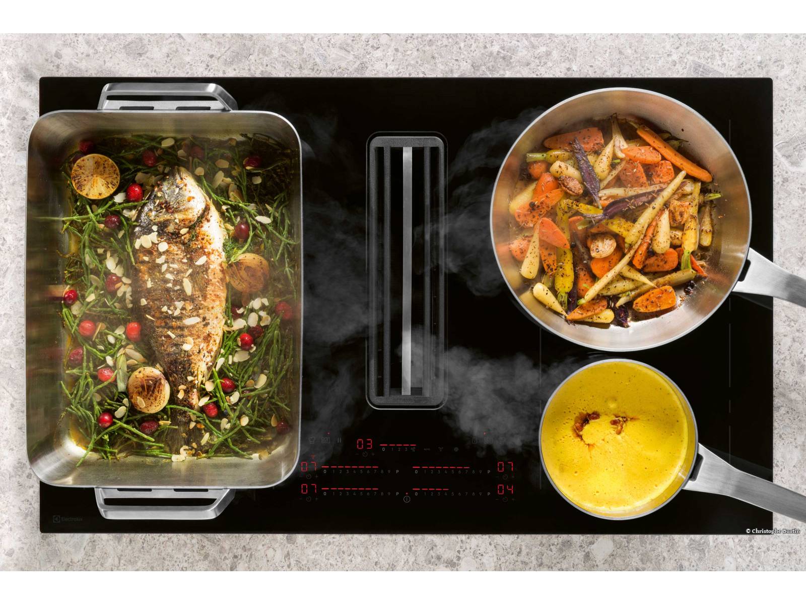 Flexibilität beim Kochen bietet das Induktionskochfeld «Combo Flex»: Die beiden Kochzonen links und rechts von der leistungsstarken Abzugmulde lassen sich nach Bedarf zu Kochzonen unterschiedlicher Grösse oder zu einer grossen Kochfläche verbinden. Die Einstellung erfolgt über eine intuitive Slider-Bedienung. ELECTROLUX. Foto: © Christophe Bustin.