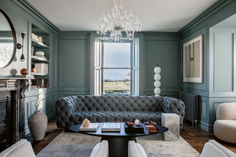 Der Salon befindet sich im historischen Hausteil, was dessen Interieur auch widerspiegelt. Den Raum dominiert das Sofa «Chester Moon» von Baxter in blaugrauem Leder. Passend dazu sind die Vertäfelungen der Wände im Farbton «De Nimes» von Farrow & Ball gestrichen. Couchtisch: «Ufo» von Emmemobili; Sessel: «Cubo» von Espasso; Stehleuchte: «Mankai» von Man of Parts; Fotos: Patrick Scott.