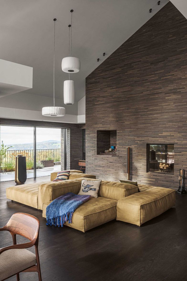 Auf Sofas von Living Divani wird relaxt. Das Mohair-Plaid ist von der finnischen Textildesignerin Lena Rewell; die skulpturalen Deckenleuchten aus der «ToTeM Family»-Kollektion von Aqua Creations.