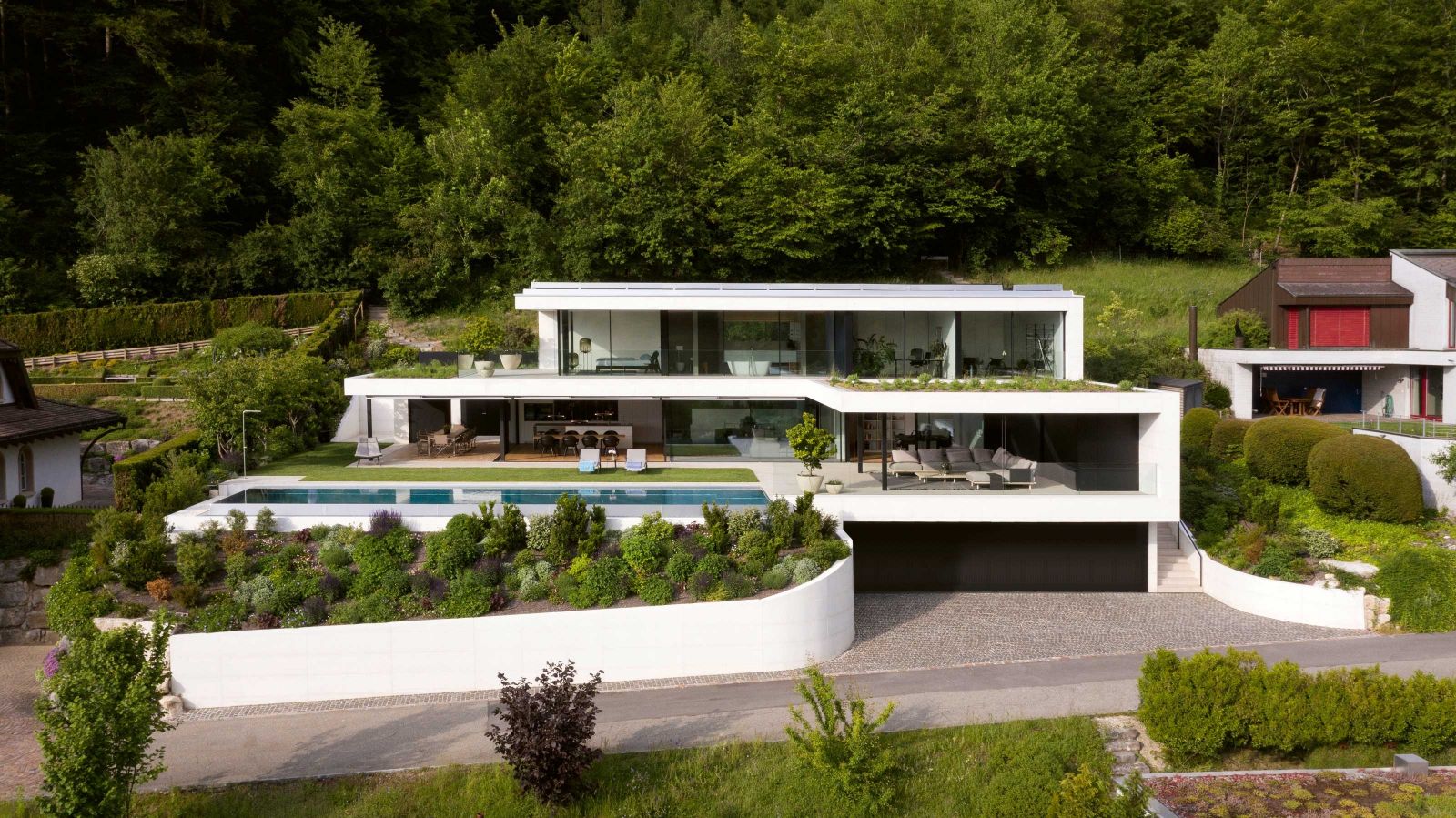 Nicht nur optisch auf der Höhe der Zeit: Das Haus besitzt eine Photovoltaikanlage inklusive Stromspeicher. Hinter dem 8.60 Meter breiten Garagentor gibt es Ladestationen für Elektroautos und E-Bikes.