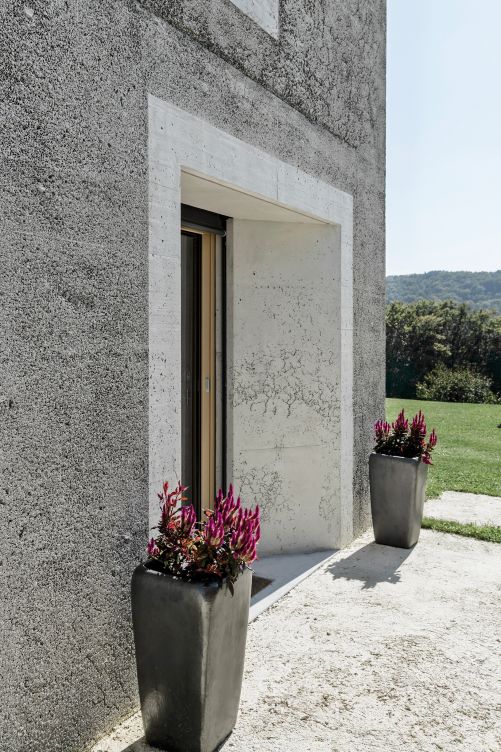 Die Rauheit der ­Aussenwände wird durch Sandstrahlung erzeugt, als optischer Akzent wurden die Fenstergewände von dieser Technik ausgespart.