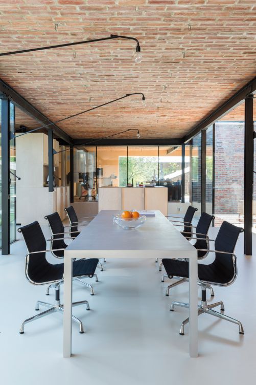 Der Raum lebt vom Wechsel der Materialien. Die Glaswände und die Decke aus Backsteinen wurden mit einem fugenlosen Bodenbelag kombiniert. Ein alter Heissluftschacht ermöglichte es, den Boden abzusenken, um die gewünschte Raumhöhe zu erhalten.