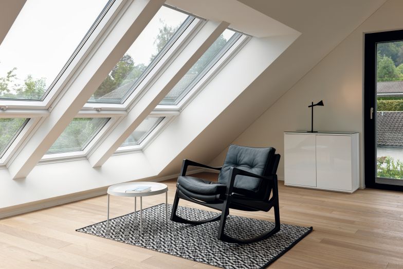 Grosse Dachflächenfenster ermöglichen einen maximalen Lichteinfall und begünstigen zudem die Fläche des Dachraumes, der ohne Kniestock ausgeführt und dadurch bis in jede Nische begehbar ist. Schaukelstuhl «Euvira» von Classicon.