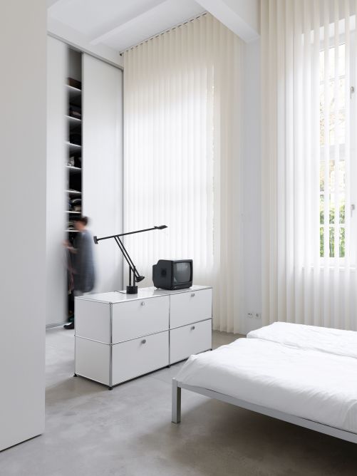 Stauraum bieten neben deckenhohen Einbauschränken weisse Regalsysteme von USM.