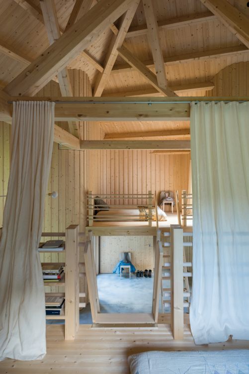 Ein Blick von der Gästegalerie zum Eingang – die Dachstruktur ist eine Installation der Künstlerin Miki Tallone. Über dem Eingangsbereich liegt die Schlafgalerie des Hausherrn, erreichbar durch eine steile Holztreppe.