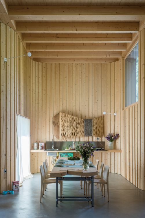 Die Küchenschränke der Bauherrin verstecken sich hinter einer Kunstinstallation von Lorenzo Cambin an der Ostwand, ergänzt durch eine einfache Küchenzeile und einen kleinen, von den Kindern bemalten Kühlschrank.