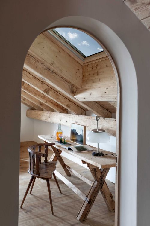 Der Blick in den Himmel inspiriert, wenn Pietro oder Alessandra an dem kleinen Schreibtisch aus Holz arbeiten. Wie der Stuhl stammt auch der Tisch von Engiadina Antik aus Zernez. Tischleuchte: «Alfa» von Enzo Mazza für Artemide. 