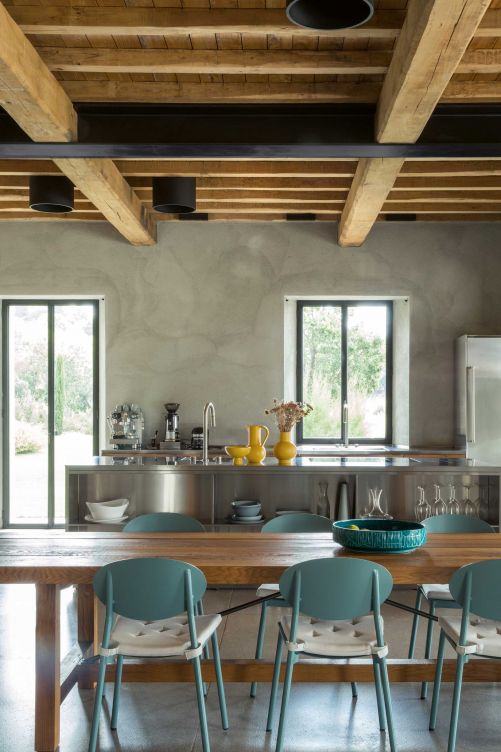 An heissen Sommertagen sorgt die Stahlküche für eine wenn auch nur optische Abkühlung. Die sonnengelbe Keramik von Raawii bringt die blaugrünen Stühle von House Doctor zum Leuchten. Obstschale: Bitossi.