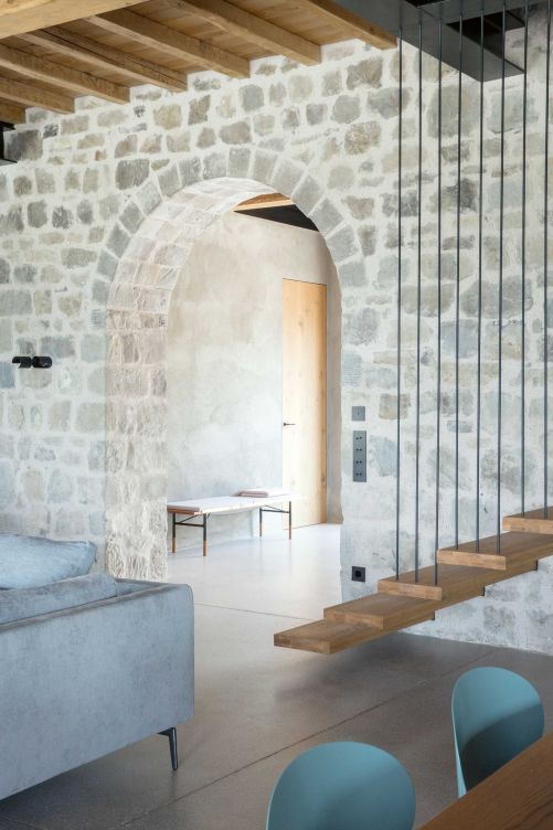 Einfache Holzstufen führen vom kombinierten Wohn-, Ess- und Küchenbereich über die Galerie ins Obergeschoss mit acht Schlafzimmern.