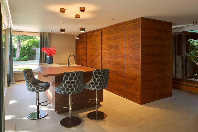 Die Küche wurde in den 1960ern für einen Haushalt mit Personal konzipiert. Sie befand sich in einem sehr kleinen Raum mit Blick zur Strasse hin. Heute entspricht sie mit einer Insel und viel Stauraum modernen Bedürfnissen. Die Barstühle liessen Karin Grossenbacher und Doina Jung eigens mit Stoffen von Designers Guild beziehen. 