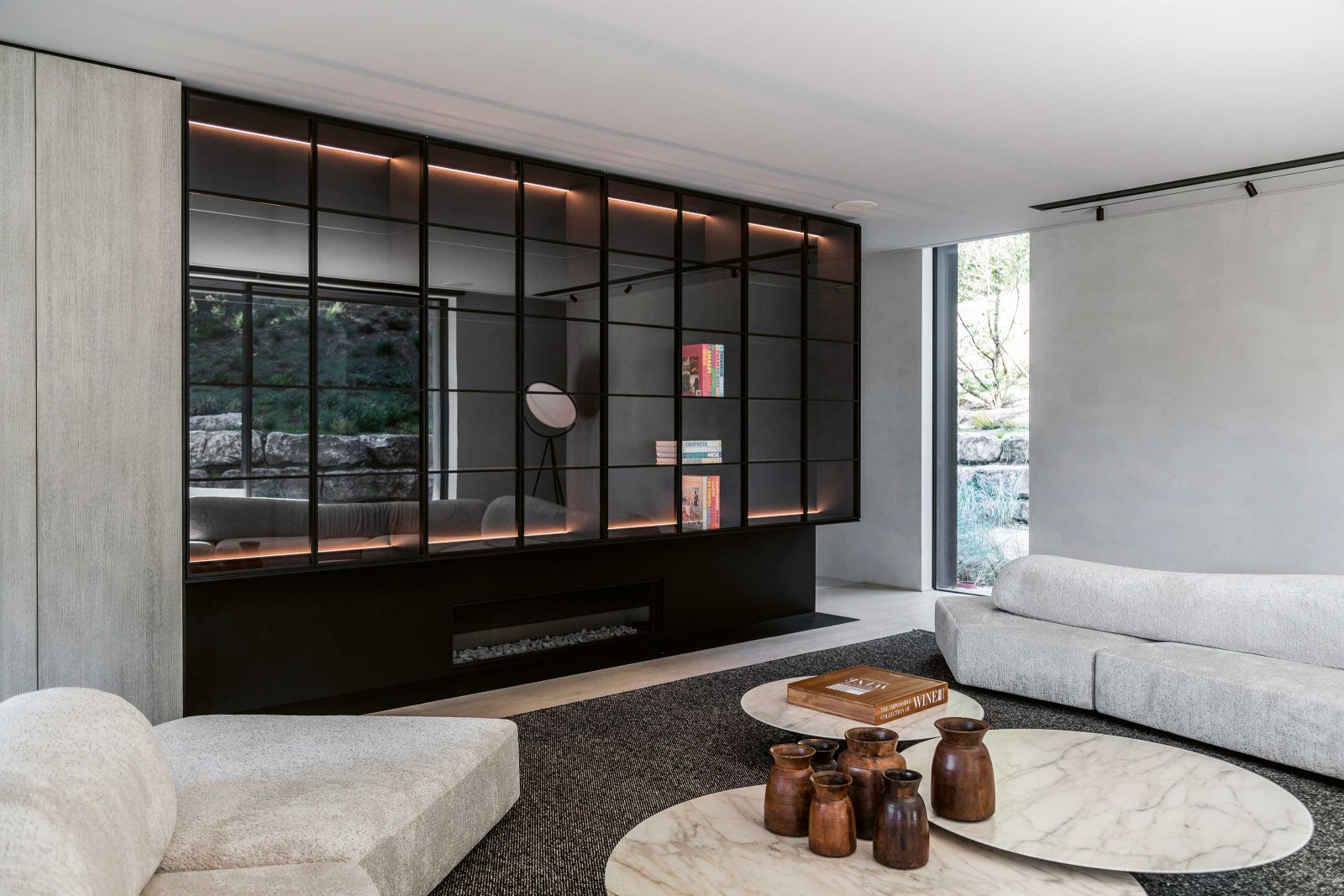 Ein exklusiv von Instore designtes Regal sorgt im Wohnbereich für Stauraum. Am modularen Sofa «On the Rocks» von Francesco Binfaré für Edra bieten Tische von Piero Lissoni für Knoll International Platz für allerlei Schönes und Nützliches. Die Beleuchtung stammt von Flos und DeltaLight.