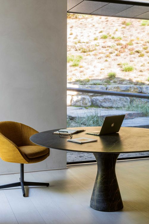 Ein kleiner Arbeits- und Besprechungsraum, der direkt neben dem Eingang liegt, ermöglicht das Arbeiten von Zuhause aus. Tisch «Alinea» von Leo Aerts für B&B Italia; Stuhl «Russell» von Minotti.