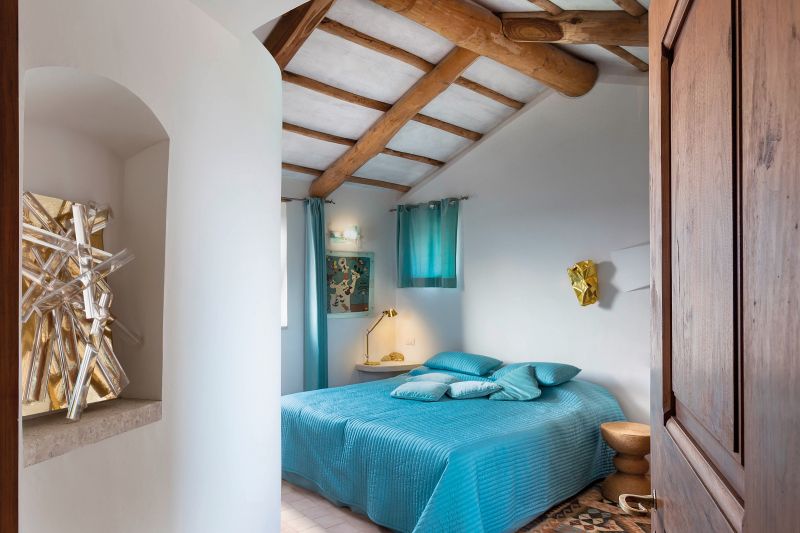 Auch Kunst spielte in den Bauten eine entscheidende Rolle. In seinem Spätwerk tauchen immer wieder Skulpturen der Architektin und Künstlerin Tiziana Lorenzelli auf. In «Il Faro» findet man sie im Aussen-, wie auch im Innenbereich, wie hier über dem Bett im Gästeschlafzimmer.