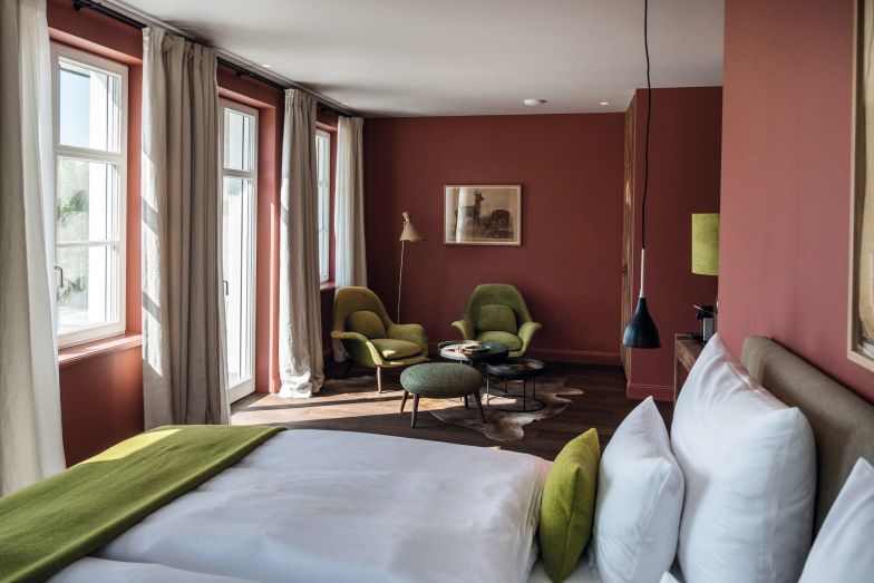 In Loge Nr. 1 geniesst man den Blick Richtung Südosten. Sie ist vollständig barrierefrei und vermittelt mit ihren warmen Rot- und frischen Grüntönen ein behagliches Wohngefühl. Stimmig kombinierte Accessoires runden das Styling des Zimmers ab. Das Bett ist wie in jedem Zimmer von der Bettenmanufaktur Schramm.