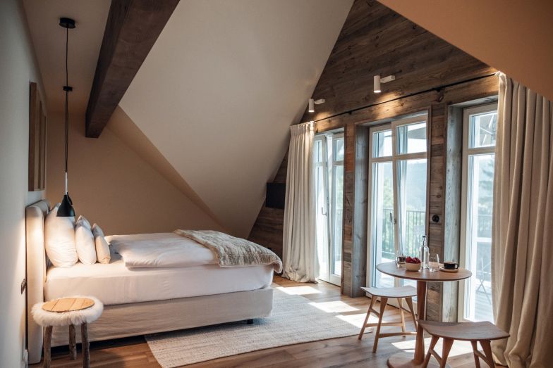 Eine Junior-Suite unter dem Dach mit Penthouse-Feeling findet sich in Loge 8, die in sanften Weiss- und Beigetönen gehalten ist. Hier schläft man in Betten der Manufaktur Schramm. Vom eigenen Balkon aus blickt man auf Wiesen, Hügel bis hin zu den Allgäuer und österreichischen Bergen.