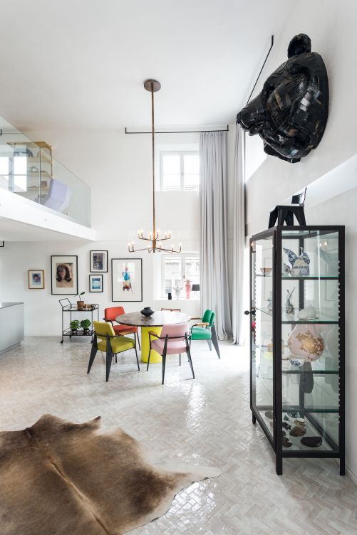 Lange Vorhangstoffe machen den Raum wohnlich und verbessern die Akustik. Auf der Galerie über der Küche befindet sich ein Büro. Vasen (im Fenster) «Showtime» von Jaime Hayon für BD Barcelona. Esstisch «Hiroki» von Philipp Mainzer für e15. Stühle «Fauteuil Direction» von Jean Prouvé für Vitra. Leuchter «Epsilon» von Massimo Castagna für Gallotti & Radice.