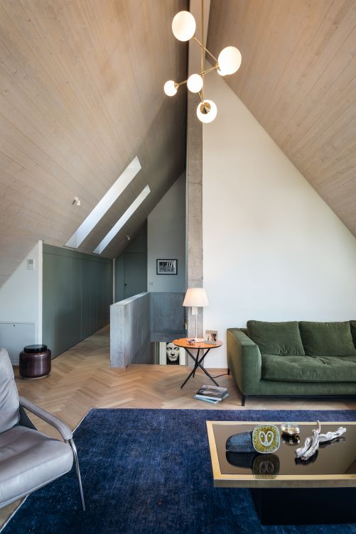 Für ein Sofa gab es im Erdgeschoss keinen Platz mehr. Nun steht es zusammen mit dem Fernseher im Dachgeschoss. Sofa von Minotti. Sessel «Maggiolina» von Marco Zanuso für Zanotta. Leuchte und Tisch, Vintage.