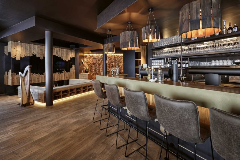 Eigentlich war geplant, viel Altholz aus dem Abbruch zu verwenden. Doch im November 2020 zerstörte ein Brand die Tischlerei, in der alles eingelagert war. Nur eine alte Schindelwand wurde gerettet, die jetzt gleich neben der Bar im Eingangsbereich zu sehen ist. Das restliche Altholz stammt vom Haus des Grossvaters, welches kurz zuvor abgerissen wurde.