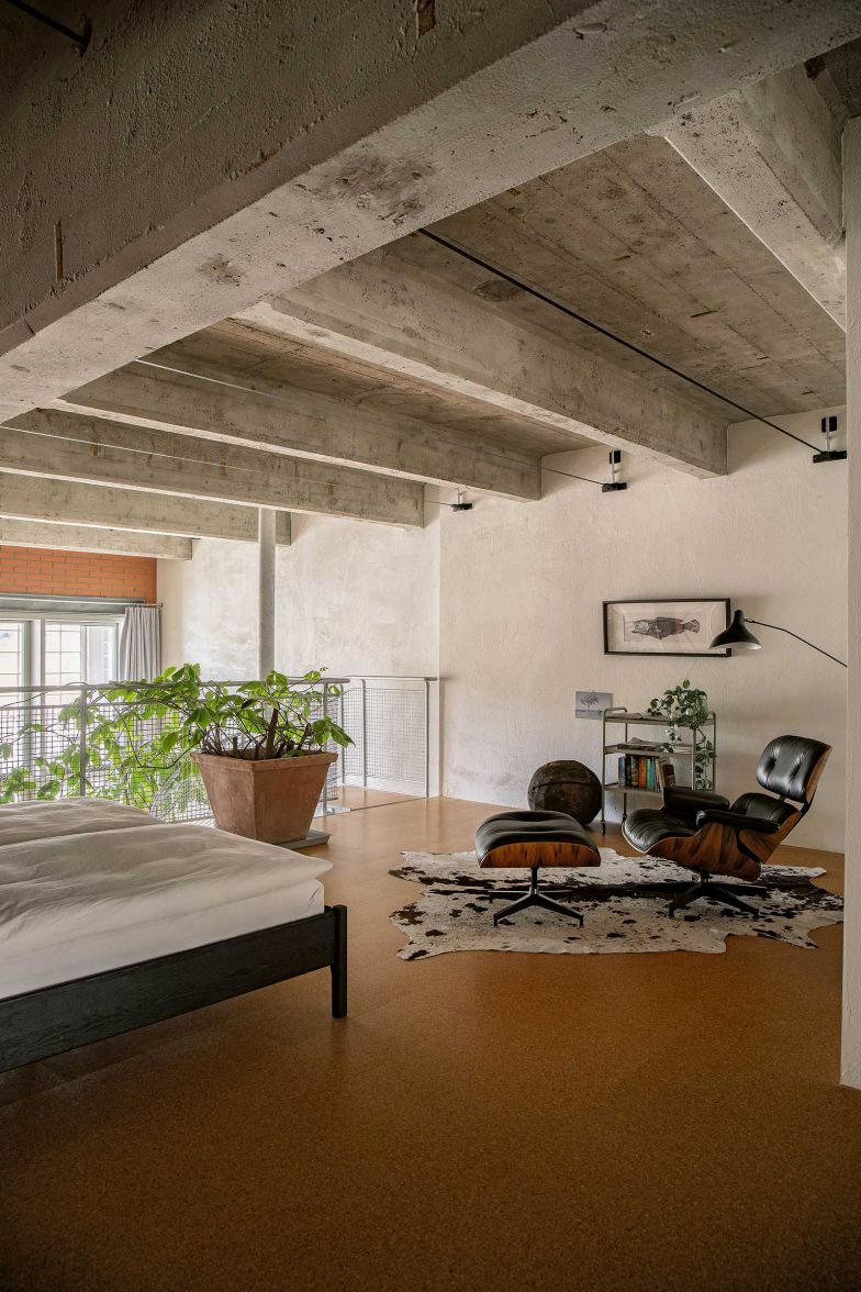 Andri Mengiardi und Martina Isler haben ihr Schlafzimmer auf der Galerie. Der «Eames Lounge Chair» von Herman Miller ist ein Original. Der Bauherr importierte ihn aus den USA.