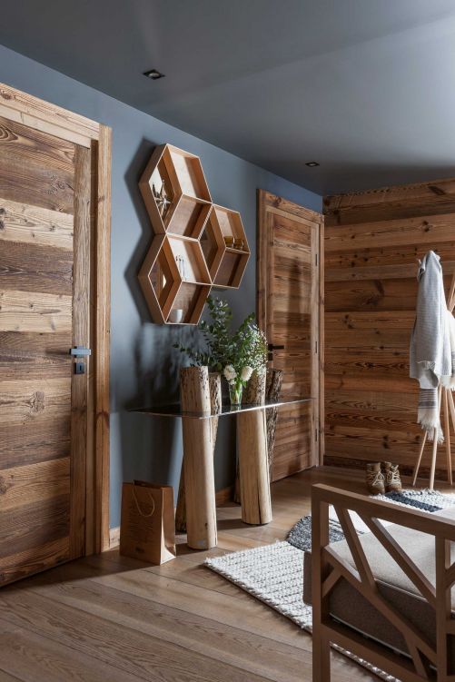 Bereits der Eingangsbereich zeigt die Affinität der Bewohner für Design. Der Wollteppich «Manga» von Patricia Urquiola begrüsst hereintretende Gäste. Die Konsole «Venice Design» ist ein Entwurf von Claudio Bellini für Riva 1920; die verspiegelten Regale stammen von Ferm Living.