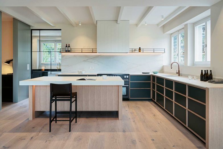 Die massgefertigte Küche mit zentraler Insel ist auf Geselligkeit ausgelegt, ­gross­zügig, kommunikativ und mit einem hohen gestalterischen Anspruch. Eine zweite, diskret ­platzierte Nebenküche im Hintergrund bietet mehr Platz im Alltag und ermöglicht viel­fältige Nutzungsmöglichkeiten.