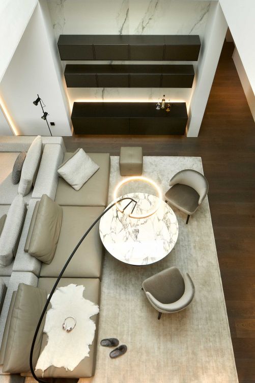 Der Blick vom offenen Treppenhaus in den Wohnraum offenbart neue Perspektiven. Das helle, aufeinander abgestimmte Interieur wirkt elegant; Möbel von bekannten Marken wie Minotti, Occhio und Poliform verströmen internationales Flair.