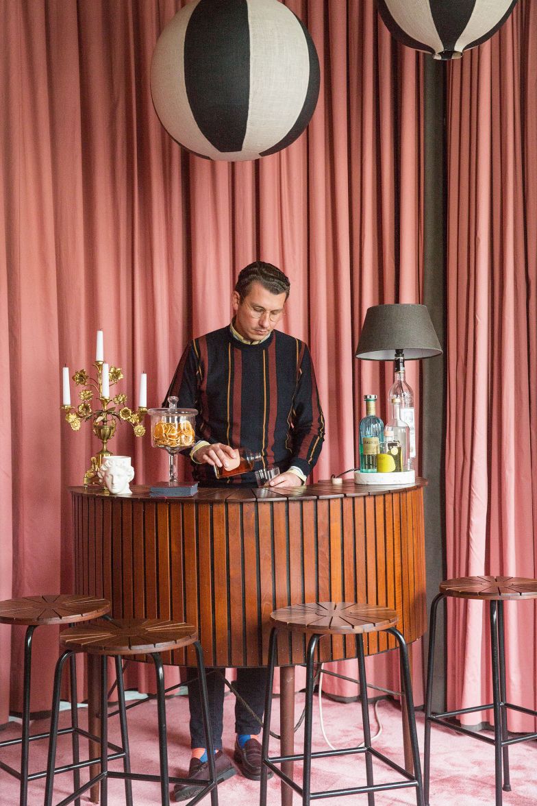 Vorhang auf und Party ab: Die Bar aus den 1960er-Jahren hat Fabian Freytag bei Ebay-Kleinanzeigen entdeckt. Auf der Bar stehen ein üppiger Vintage-Kerzenständer und eine Tischleuchte aus einer «Chelsea Farmersclub»-Wodkaflasche. Die Pendelleuchten sind handgefertigt in Berlin von Studio Berk.