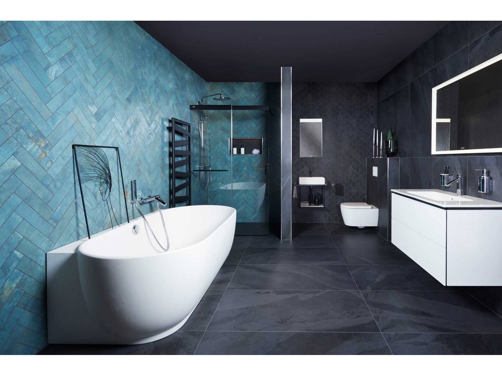 Die edlen Wandplatten in Smaragdgrün laden zum Verweilen im Wannenbad ein. Der Übergang von schwarzen grossformatigen Keramikplatten zum kleineren Polygonformat verleiht dem Raum zusätzliche Tiefe. SABAG.