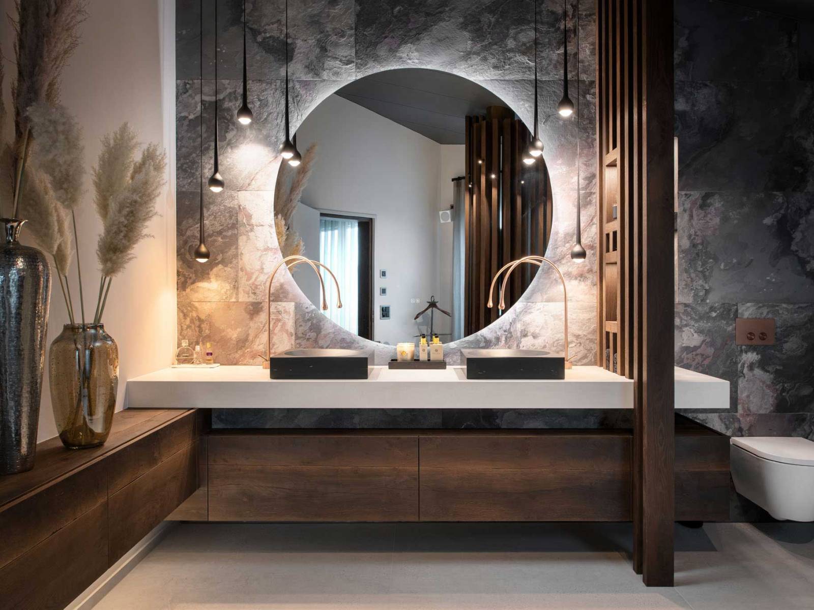 Badmöbel, Leuchten, Keramik und Fliesen passen sich perfekt in die architektonischen Gegebenheiten ein und verbinden sich zu einem harmonischen Ganzen: Dieses Beispiel zeigt, dass der Inneneinrichtungsspezialist aus Pfäffikon sein Handwerk aufs Beste versteht. Foto: Daniel Blake. Rolf Zürcher AG.