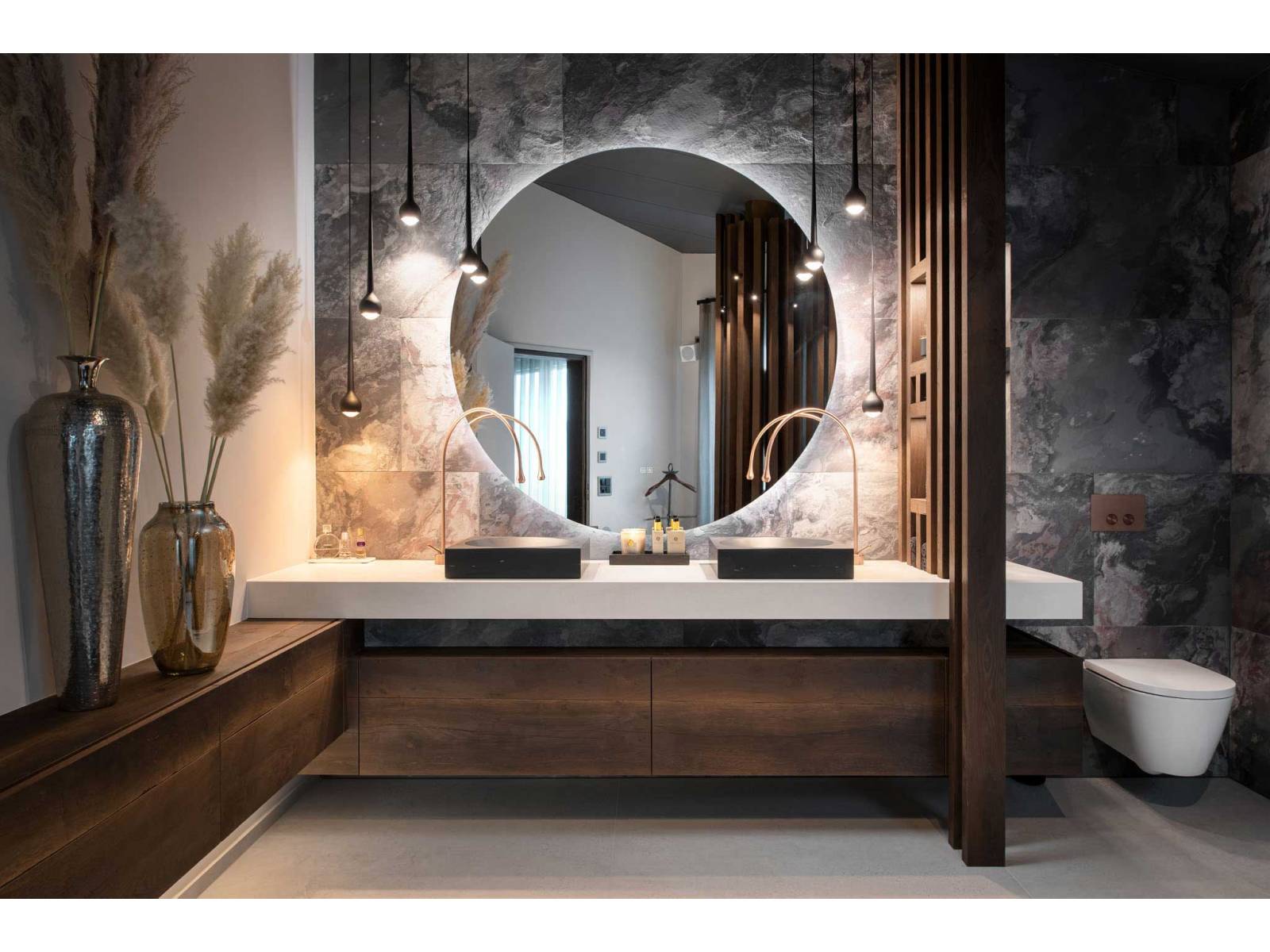 Badmöbel, Leuchten, Keramik und Fliesen passen sich perfekt in die architektonischen Gegebenheiten ein und verbinden sich zu einem harmonischen Ganzen: Dieses Beispiel zeigt, dass der Inneneinrichtungsspezialist aus Pfäffikon sein Handwerk aufs Beste versteht. Foto: Daniel Blake. Rolf Zürcher AG.