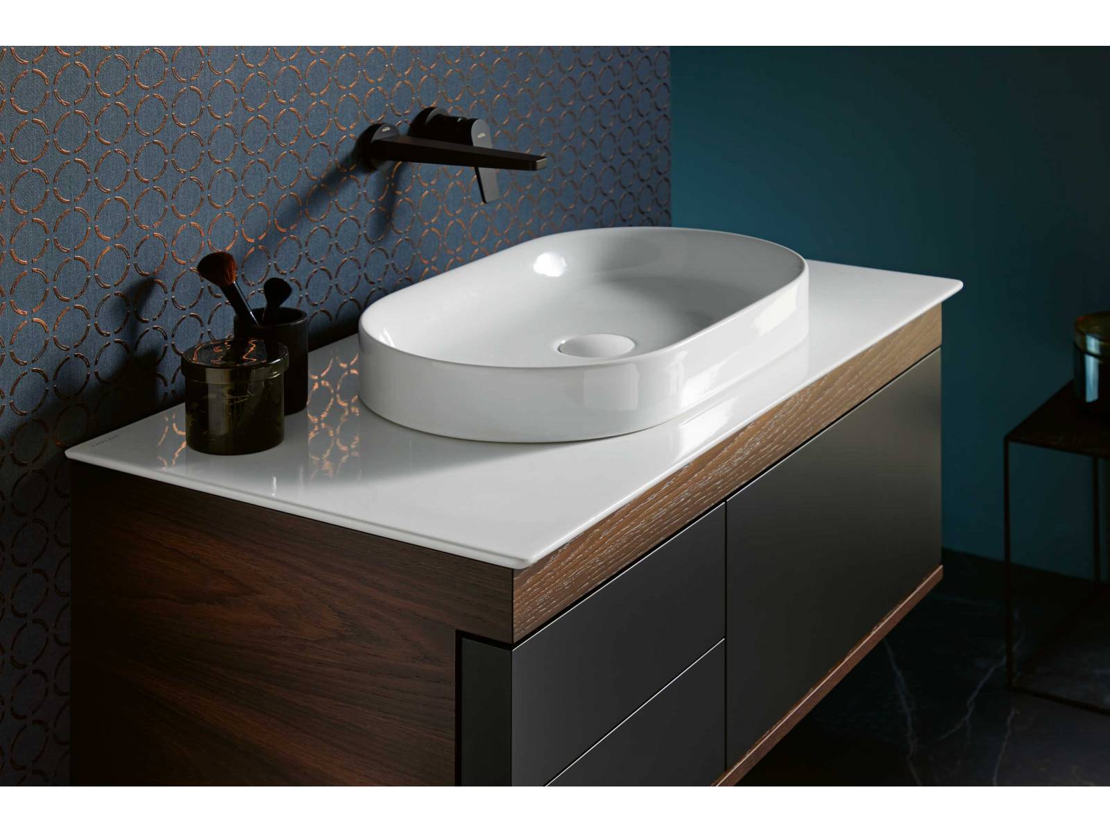 Für die Waschtische «Logica Plus» ist die aufein-ander abgestimmte Geometrie des breiten oberen Frontabschlusses mit den darunter liegenden Elementen bezeichnend. Der Korpus ist lackiert oder in Echtholz furniert erhältlich, die Front ist immer lackiert. Das Modell mit Schubladen kann nur mit einem Aufsatzwaschbecken kombiniert werden. SANITAS TROESCH.