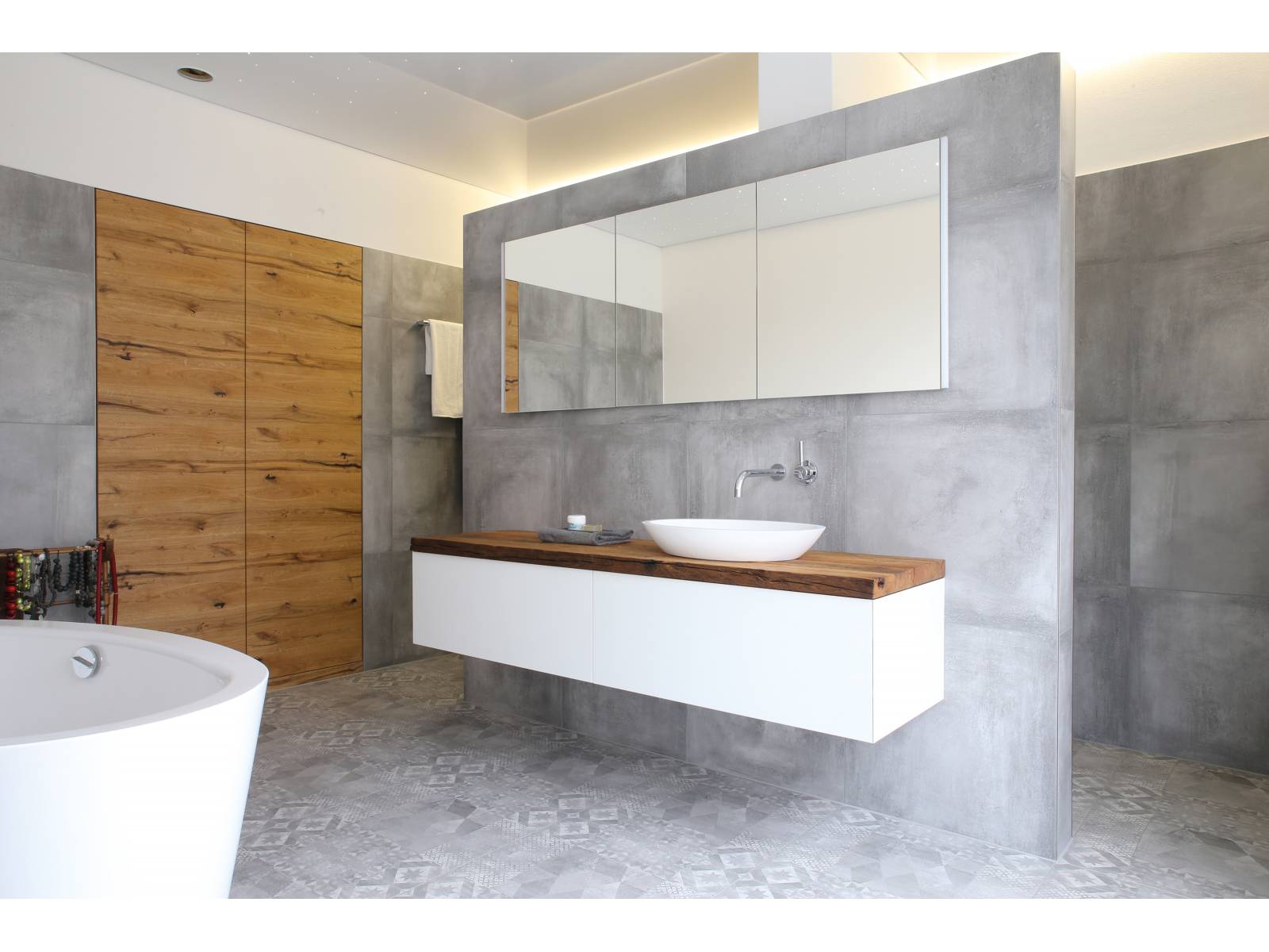 Alt und neu gekonnt kombiniert: Auf dem wandhängenden Möbel mit der Massivholzabdeckung in Altholz macht sich das schlichte Aufsatzwaschbecken besonders gut. Loosli.