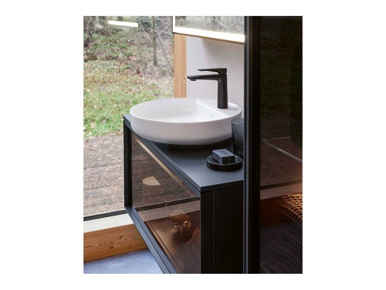 Geradlinige Konsolenunterschränke mit feinen Metallrahmen und Fronten aus hinterleuchtetem Glas, Holz oder verschiedenen Dekoren, dazu eine runde Aufsatzschale oder ein rechteckiges Waschbecken – so präsentiert sich das natürlich wirkende Badmöbelprogramm «Vitrium» von Christian Werner. DURAVIT.