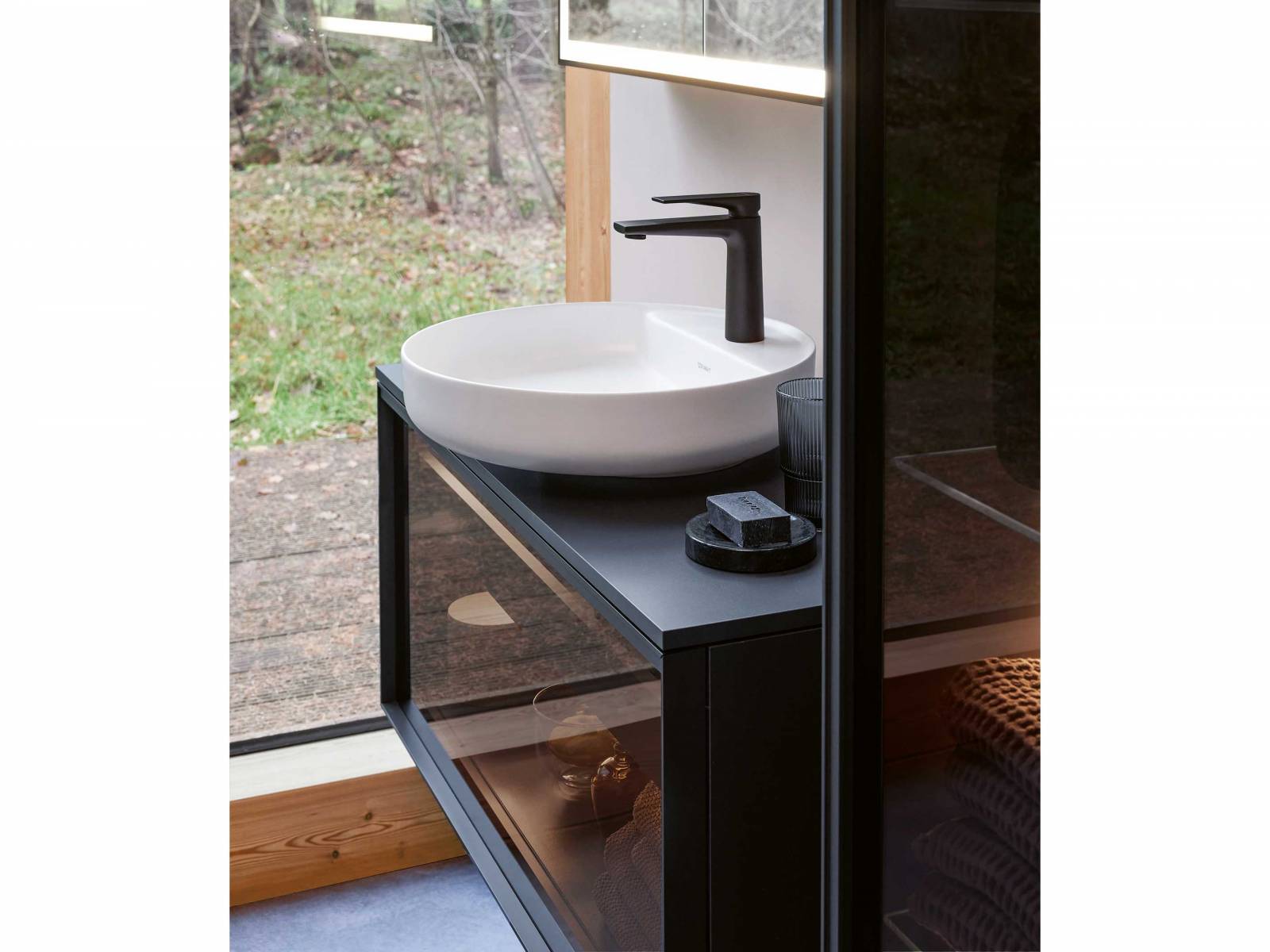 Geradlinige Konsolenunterschränke mit feinen Metallrahmen und Fronten aus hinterleuchtetem Glas, Holz oder verschiedenen Dekoren, dazu eine runde Aufsatzschale oder ein rechteckiges Waschbecken – so präsentiert sich das natürlich wirkende Badmöbelprogramm «Vitrium» von Christian Werner. DURAVIT.