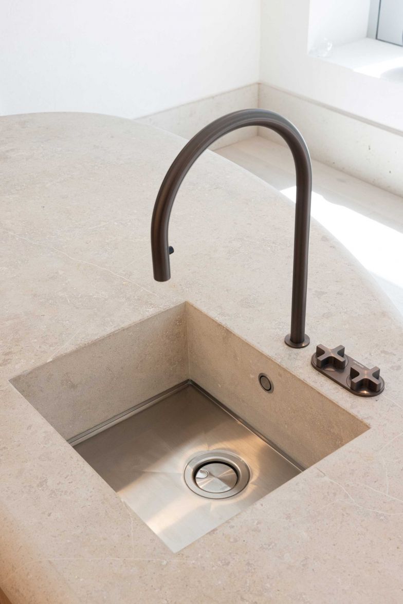 Die Abdeckung der Kücheninsel besteht aus einem Pietra di Medici-Stein.