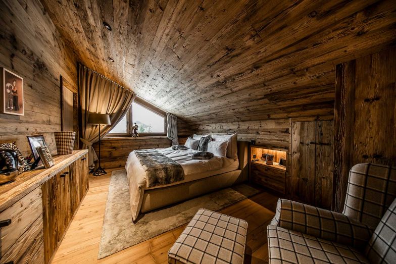 Altholzmöbel, wollige Textilien und alpine Accessoires im Schlafzimmer sorgen für Geborgenheit und schaffen einen Rückzugsort mit Charakter.