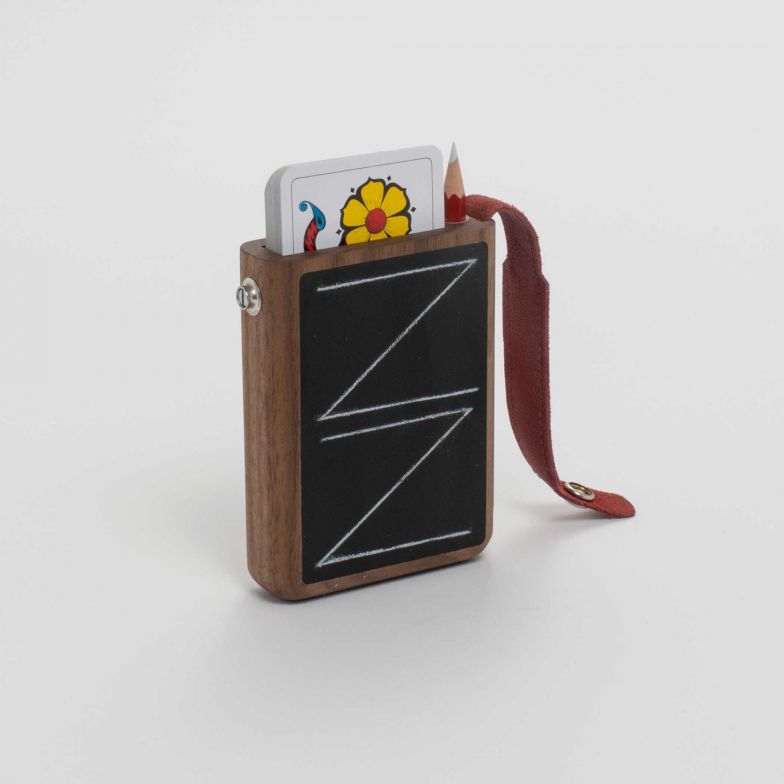 «Täsche Trompf» ist ein kompaktes Schweizer Allround Jassset. Mit den beeinhaltenden Karten, dem Kreidestift und der Schreibtafel ist man immer für ein gutes Spiel vorbereitet. Sollte der Kreidestift stumpf werden, lässt er sich ganz einfach im eingebauten Spitzer wieder spielbereit machen. Design: Julian Villiger und Oliver Müller