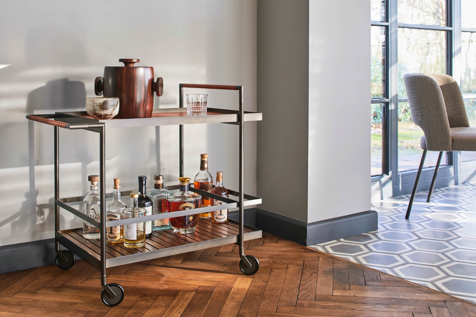 Barwagen «Harri» präsentiert sich als Cocktail aus massivem Nussbaum, filigran mit Leder umwickelten Griffen und einer hochwertigen Metallplatte. Design: Peter Fehrentz.  