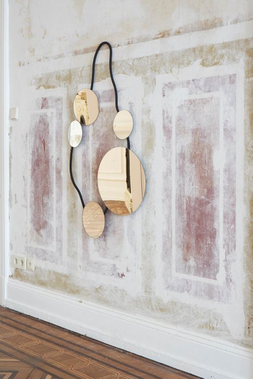 Fünf unterschiedlich grosse, bronzegetönte Spiegel, die durch einen mit Textil bezogenen Stahldraht verbunden sind, machen aus einem Spiegel einen Wandschmuck der besonderen Art. «Wall Jewellery» vereint Design und Kunsthandwerk und wird an jeder Wand zum Eyecatcher. Design: Nomad. Ligne Roset.