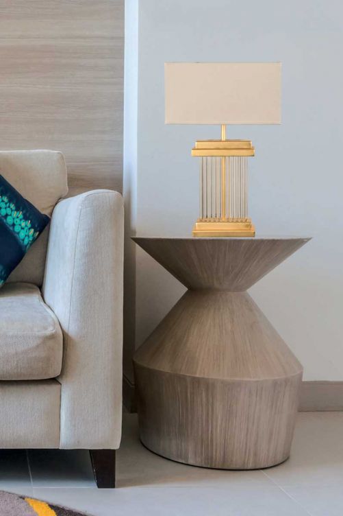 Der zylinderförmige Fuss der Tischleuchte «Vienna» wirkt wie eine kostbare Säule. Sie ist aus Glas und goldfarbenem Metall, passend dazu der dezente, textile Schirm. 