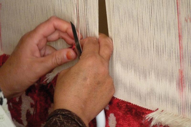 Eine Knüpferin braucht je nach Grösse und Knotendichte des Teppichs mehrere Monate, bis er fertig gestellt ist.