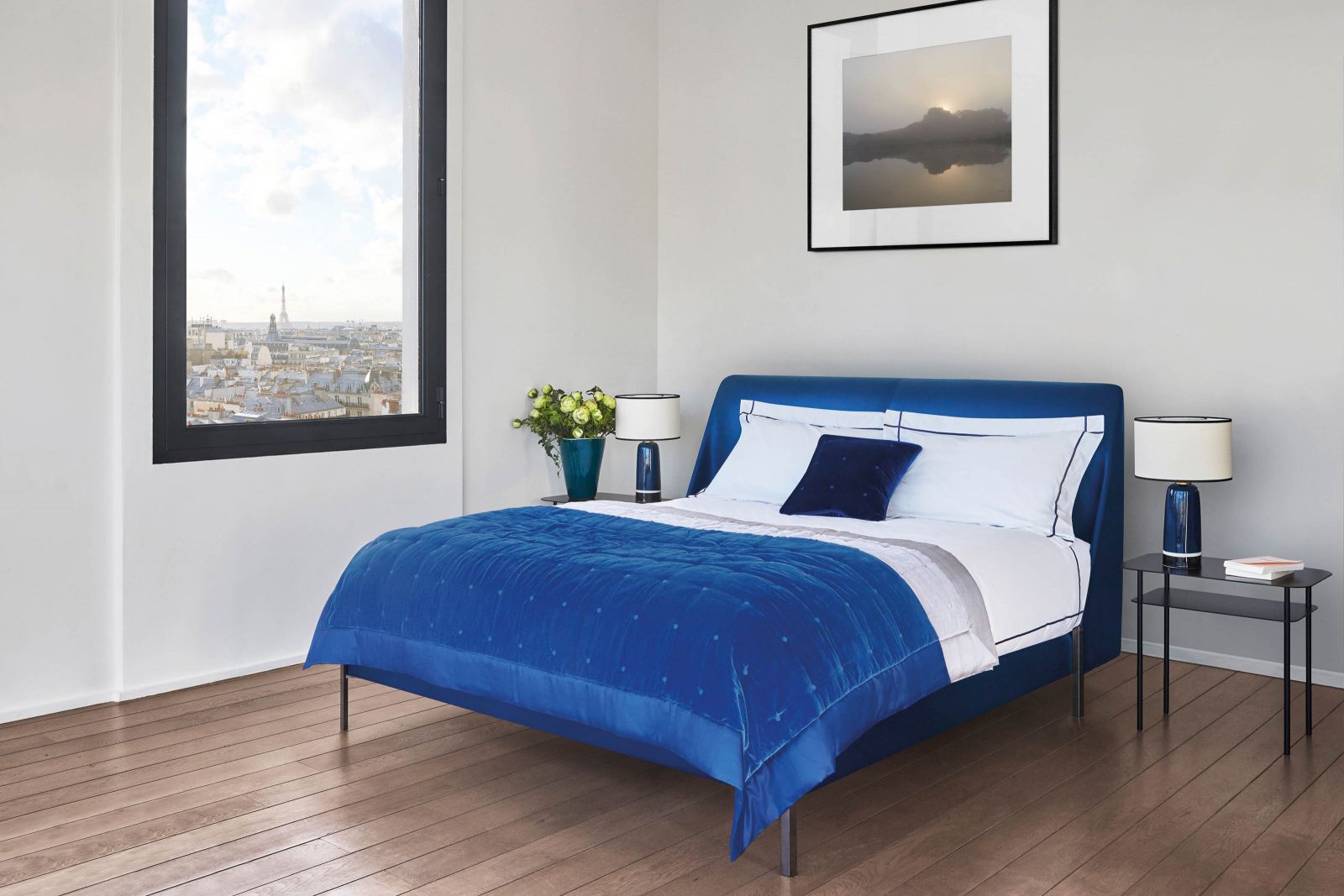 Für Gemütlichkeit und Geborgenheit sorgt das Kopfteil «Margot» mit sanft nach innen gebogener Formen. Überwurf und Kissen in leuchtendem Blau greifen den im Trend liegenden Samt auf. Design: Quaglio Simonelli.