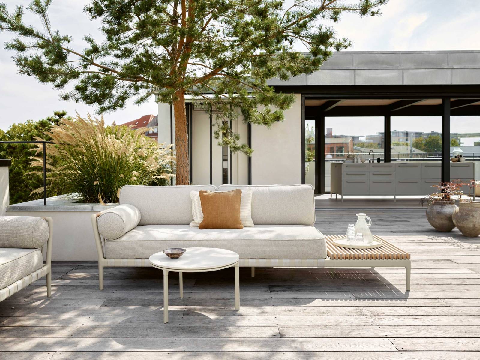 Das Sofa «Vipp 720» trotzt mit speziellen Outdoor-Materialien jeglichen Wetterbedingungen. Auf dem Gestell aus Aluminium und Edelstahl liegen schnelltrocknende Polster und Kissen, der Bezug ist UV-resistent und waschbar. An den Arm- und Rückenlehnen fallen Details aus Rattan auf, die eine optische Verbindung zu den Gurten der Basis schaffen. VIPP.