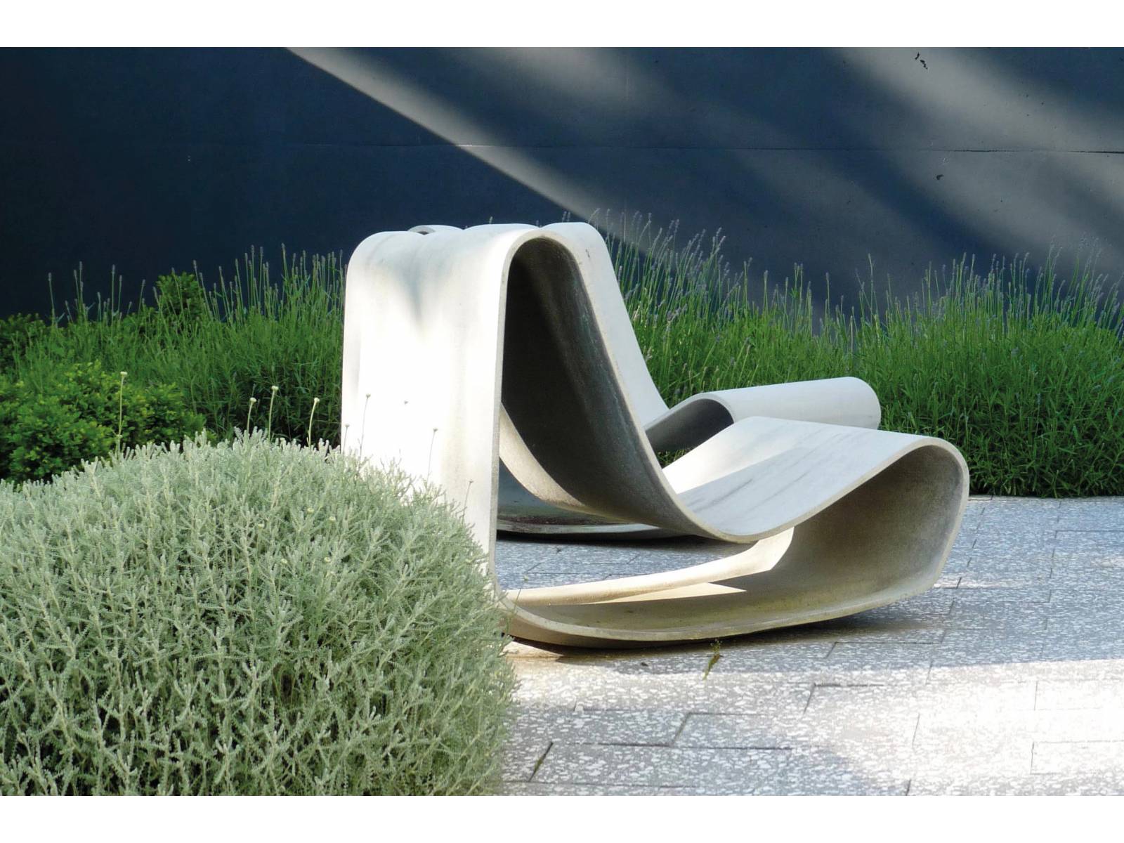Der Schlaufenstuhl «Guhl» aus  rezyklierbarem Faserzement ist der Klassiker unter den Schweizer Gartenmöbeln. Die Neuauflage seines Strandstuhls entwarf Willy Guhl 1997 anlässlich seines 80. Geburtstags. Das Designstück wird in Handarbeit hergestellt, nummeriert und signiert. Eternit.