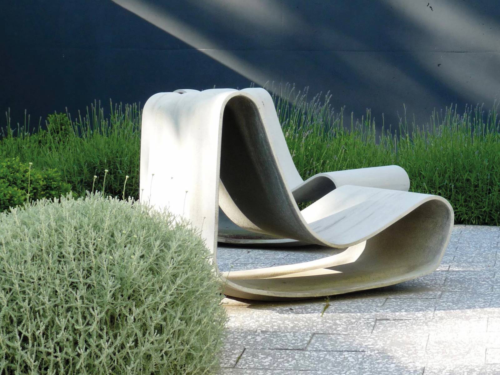 Der Schlaufenstuhl «Guhl» aus  rezyklierbarem Faserzement ist der Klassiker unter den Schweizer Gartenmöbeln. Die Neuauflage seines Strandstuhls entwarf Willy Guhl 1997 anlässlich seines 80. Geburtstags. Das Designstück wird in Handarbeit hergestellt, nummeriert und signiert. Eternit.