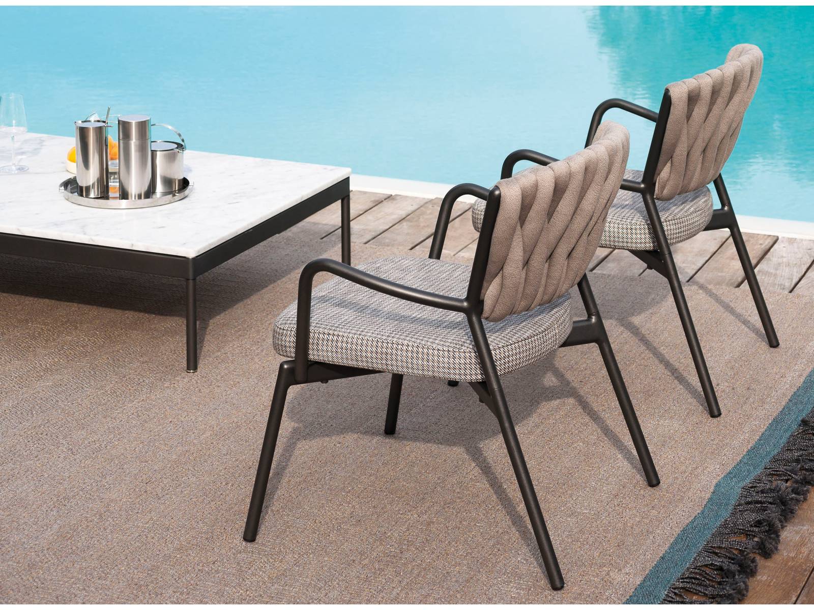 Piper bekommt Zuwachs: Die erfolgreiche Kollektion wird um einen Lounge-Sessel mit fester Polsterung erweitert. Der Bezug wird dem Rückengeflecht farblich angepasst. Das Ensemble vervollständigt Couchtisch «Basket» mit Carrara-Marmorplatte. Design: Rodolfo Dordoni. Roda.