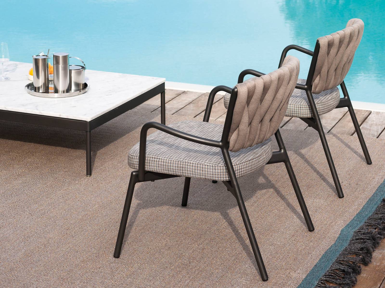 Piper bekommt Zuwachs: Die erfolgreiche Kollektion wird um einen Lounge-Sessel mit fester Polsterung erweitert. Der Bezug wird dem Rückengeflecht farblich angepasst. Das Ensemble vervollständigt Couchtisch «Basket» mit Carrara-Marmorplatte. Design: Rodolfo Dordoni. Roda.