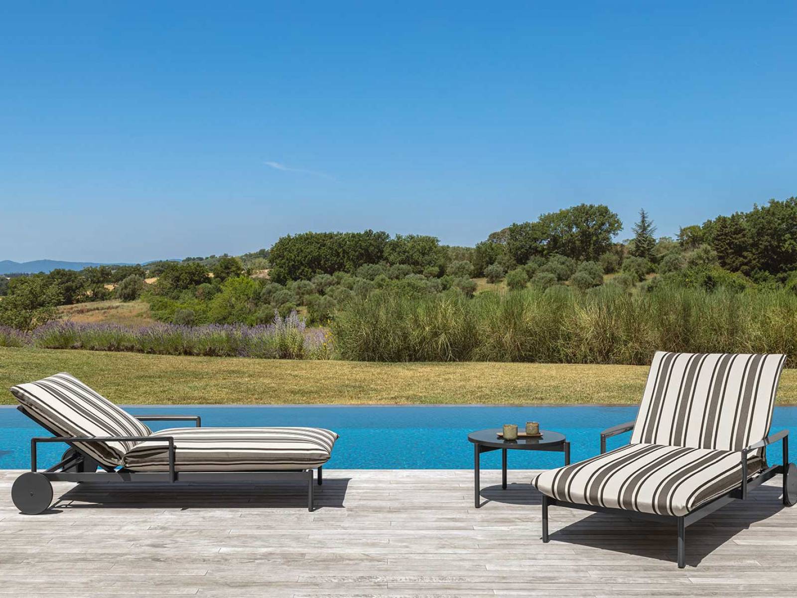 Nalu» reduziert die Outdoor-Liege auf ihre Essenz und schafft dabei ein Meisterwerk der Leichtigkeit. Die sanfte Linie der Auflage schwebt über dem Boden, als würde sie von unsichtbaren Wellen getragen. Die Kollektion von Ludovica + Roberto Palomba lädt den Betrachter dazu ein, in Gedanken zu versinken – wie am Ufer eines stillen Meeres. Talenti.