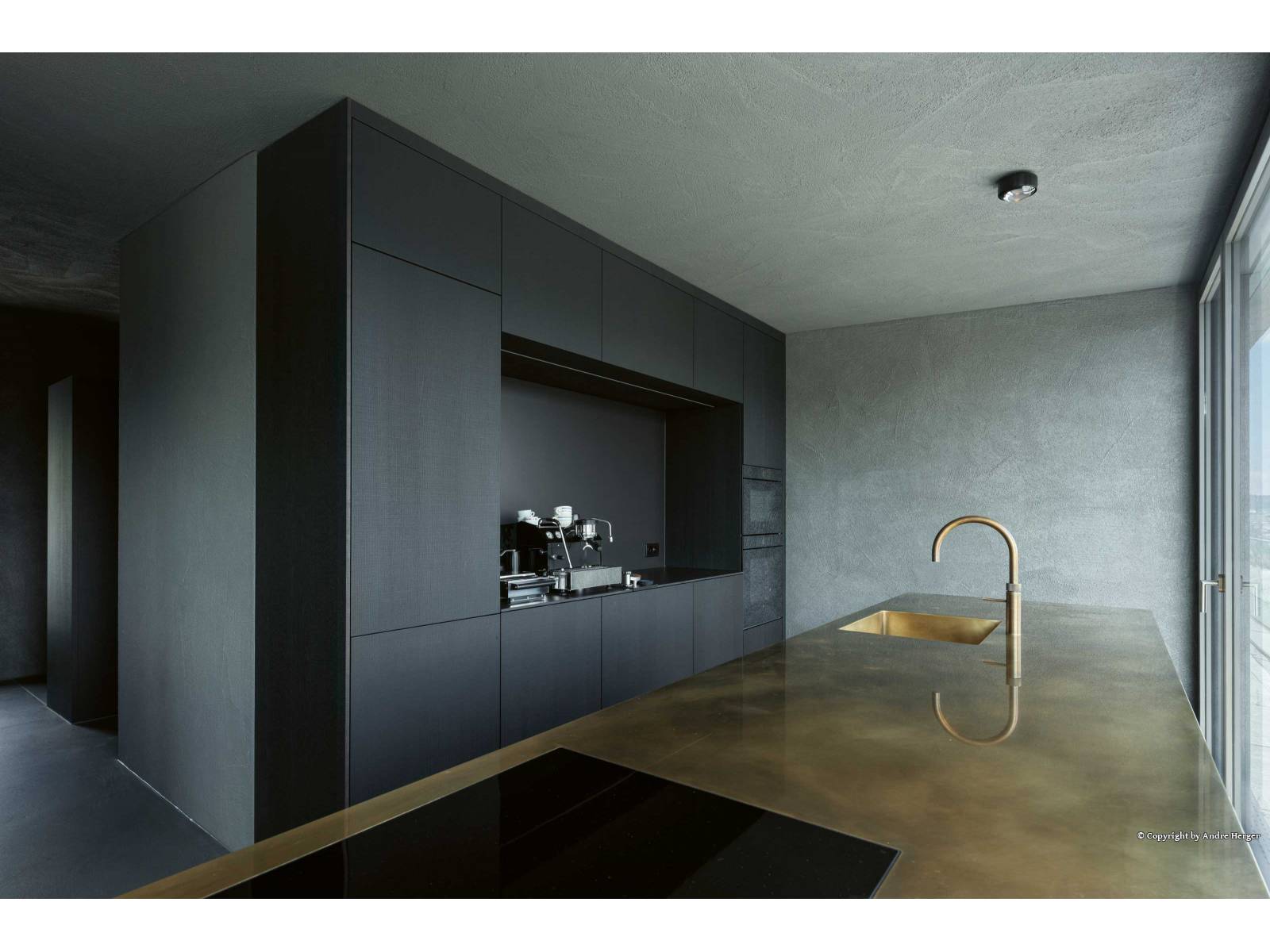 Wer im Muotathal produziert, kann nicht nur einzelne Küchenmöbel, sondern ganze Wohnkonzepte anbieten. In diesem Neubau verbergen sich hinter geräucherten Eichenfronten nicht nur Geräte und Geschirr, sondern auch viel Stauraum im Eingangs- oder Wohnbereich. Die Armatur in edlem Messing Patina liefert kaltes und kochendes Wasser. OREA / QUOOKER.